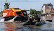 Ukrainian security forces transport local residents in a boat during an evacuation from a flooded area in Kherson on June 7, 2023, following the destruction of Kakhovka hydroelectric power plant dam. Photo by ALEKSEY FILIPPOV / AFP
