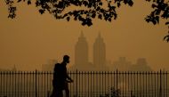 People walk in Central Park as smoke from wildfires in Canada cause hazy conditions in New York City on June 7, 2023. Photo by TIMOTHY A. CLARY / AFP