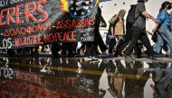 Protesters hold a banner during a protest march to the Frontex and Hellenic Coastguard headquarters in the port of Piraeus near Athens, on June 18, 2023, following the deadly shipwreck which costed lives of at least 78 migrants. (Photo by Louisa GOULIAMAKI / AFP)