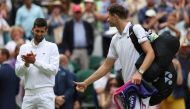Poland's Hubert Hurkacz gives a thumbs-up to Serbia's Novak Djokovic after being defeated during their men's singles tennis match on the eighth day of the 2023 Wimbledon Championships at The All England Tennis Club in Wimbledon, southwest London, on July 10, 2023. (Photo by Adrian DENNIS / AFP)