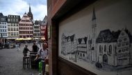 A man with a scooter looks at a street cafe at the Roemerberg square in central Frankfurt am Main, western Germany, on July 26, 2023. (Photo by Kirill KUDRYAVTSEV / AFP)