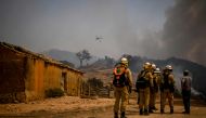 Personnel of the Protection and Relief Intervention Group (GIPS) specialised in combating forest fires, arrive to battle a wildfire in Reguengo, Portalegre district, south of Portugal, on August 8, 2023. (Photo by Patricia De Melo Moreira / AFP)