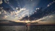 A sculpture of a moon crescent, created by the artist Pavlos Vasileiadis, is displayed at sunset along the waterfront of Thessaloniki on August 20, 2023. Photo by Sakis MITROLIDIS / AFP