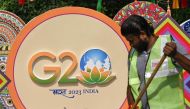 A municipal worker cleans a road near a G20 India summit logo ahead of its commencement in New Delhi on September 3, 2023. (Photo by Sajjad HUSSAIN / AFP)