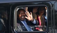 File photo: Gabonese President Ali Bongo Ondimba waves from his car upon his arrival in Libreville on March 23, 2019. (Photo by Steeve Jordan / AFP)