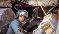 A rescuer searches for survivors under the rubble of a house destroyed in an earthquake in Moulay Brahim, Al-Haouz province, on September 9, 2023.  Photo by FADEL SENNA / AFP