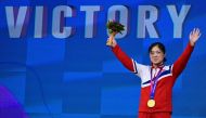 North Korea's Kim Il Gyong celebrates with her gold medal during the medal ceremony for the women's 59kg group A weightlifting competition during the Hangzhou 2022 Asian Games in Hangzhou, in China's eastern Zhejiang province on October 2, 2023. (Photo by Ishara S. Kodikara / AFP)