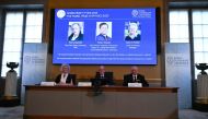 (L-R) US-based physicist Pierre Agostini, Hungarian-Austrian physicist Ferenc Krausz and French physicist Anne L' Huillier appear on the screen as member of the Royal Swedish Academy of Sciences Chair of the Nobel Committee for Physics Eva Olsson, Secretary General of the Royal Swedish Academy of Sciences and Member of the Nobel Committee For Physics speak during the announcement on October 3, 2023. (Photo by Jonathan Nackstrand / AFP)
