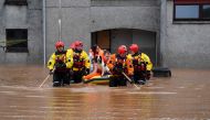 A couple and their dog are rescued by a Coastguard team from a flooded street in Brechin, northeast Scotland, on October 20, 2023 as Storm Babet batters the country. Photo by ANDY BUCHANAN / AFP