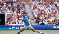 Novak Djokovic of Serbia hits a forehand during his Men's Singles Quarterfinal match against Taylor Fritz of the United States. Clive Brunskill/Getty Images/AFP

