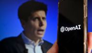 This illustration photo produced in Arlington, Virginia on November 20, 2023, shows a smart phone screen displaying the logo of OpenAI juxtaposed with a screen showing a photo of former OpenAI CEO Sam Altman attending the Asia-Pacific Economic Cooperation (APEC) Leaders' Week in San Francisco, California, on November 16, 2023. (Photo by Olivier Douliery / AFP)