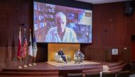 Dean of GU-Q Dr. Safwan Masri (right) and Associate Professor of History at GU-Q Dr. Abdullah Al Arian (left) on the stage while Dr. Norman Finkelstein is speaking virtually at the public event in Doha.