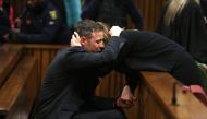 (FILES) South African Paralympian Oscar Pistorius reacts as his sister holds him during the third day of his resentencing hearing for the 2013 murder of his girlfriend Reeva Steenkamp at the Pretoria High Court, in Pretoria on June 15, 2016. (Photo by Alon Skuy / POOL / AFP)
