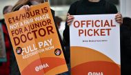 People hold British Medical Association (BMA) branded placards calling for better pay, as they stand on a picket line outside University College Hospital (UCH) in central London on April 12, 2023, during a strike by junior doctors -- physicians who are not senior specialists but who may still years of experience. Photo by Ben Stansall / AFP