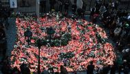 Well wishers light candles as people mourn at a makeshift memorial for the victims outside the Charles University in central Prague, on December 22, 2023, as police investigators kept working on the campus the day after a deadly mass shooting. (Photo by Michal Cizek / AFP)
