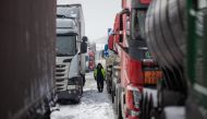 A Ukrainian truck driver is seen next to Ukrainian trucks on the parking lot near Korczowa Polish-Ukrainian border crossing, on December 5, 2023. (Photo by Wojtek Radwanski / AFP)