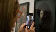 A woman takes a snapshot at the Sophie Scheidecker Gallery of France, during the inauguration of the 'Este arte' exhibition at Vik Pavilion in José Ignacio, Maldonado, Uruguay, on January 6, 2024. (Photo by Santiago Mazzarovich / AFP)
