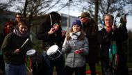 Swedish environmental activist Greta Thunberg (C) bangs a tambourine as she stands with members of the Extinction Rebellion (XR) climate change group, protesting against plans to increase private jet flights, at Farnborough Airport in Farnborough, west of London on January 27, 2024. (Photo by HENRY NICHOLLS / AFP)
