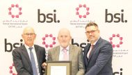 Hamad International Airport officials showcasing the award from BSI.