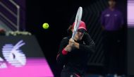 Iga Swiatek of Poland hits a return against Victoria Azarenka of Belarus during their Quarter-Final Women's Singles tennis match at the Qatar WTA Open at Khalifa International Tennis and Squash Complex in Doha on February 15, 2024. (Photo by Karim Jaafar / AFP)