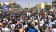 Civil society groups and political groups hold placards as they march calling on authorities respect the election date, in Dakar, on February 17, 2024. (Photo by JOHN WESSELS / AFP)
