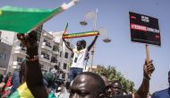 Civil society groups and political groups hold placards as they march calling on authorities respect the election date, in Dakar, on February 17, 2024. (Photo by JOHN WESSELS / AFP)
