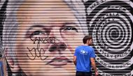 A man walks past a mural of WikiLeaks founder Julian Assange in a Melbourne laneway on March 26, 2024. Photo by William WEST / AFP. 