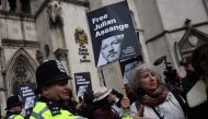 Police officers stand guard as supporters of WikiLeaks founder Julian Assange hold placards outside The Royal Courts of Justice, Britain's High Court, in central London on March 26, 2024. (Photo by Daniel LEAL / AFP)
