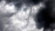 A picture taken on March 27, 2024 shows an aircraft flying amid clouds while entering Madrid airport. (Photo by OSCAR DEL POZO / AFP)