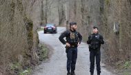 French Gendarmes discuss on the road to the French southern Alps tiny village of Le Haut-Vernet, in Le Vernet on March 31, 2024, after French investigators have found the 