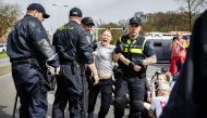 Swedish climate activist Greta Thunberg (C) is arrested during a climate march against fossil subsidies near the highway A12 in the Hague, on April 6, 2024. (Photo by Ramon van Flymen / ANP / AFP)
