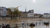 People enjoy the warm weather at the flooded docks along the Seine river in Paris on April 6, 2024. (Photo by Dimitar DILKOFF / AFP)