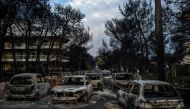 This photo taken on July 24, 2018 show cars burnt following a wildfire at the village of Mati, near Athens, on July 24, 2018. Photo by ANGELOS TZORTZINIS / AFP