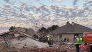 Rescue workers are seen at the scene of a collapsed building in George on May 7, 2024. (Photo by Willie van Tonder / AFP)
