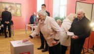 Voters arrive to cast their ballots during the first round of Lithuania's presidential election in front of a polling station in Vilnius on May 12, 2024. (Photo by PETRAS MALUKAS / AFP)
