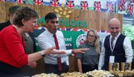 Britain's Prime Minister Rishi Sunak talks to employees of Morrison Supermarkets as he visits stalls during a 'Farm to Fork' summit in Downing Street, central London on May 14, 2024. Photo by Toby Melville / POOL / AFP.