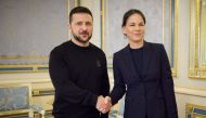 This handout photograph taken and released by the Ukrainian Presidential Press Service on May 21, 2024, shows Ukraine's President Volodymyr Zelensky (left) shaking hands with Germany's Foreign Minister Annalena Baerbock prior to their talks in Kyiv. (Photo by Handout / UKRAINIAN PRESIDENTIAL PRESS SERVICE / AFP)