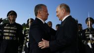 In this pool photograph distributed by the Russian state agency Sputnik, Uzbek President Shavkat Mirziyoyev welcomes Russia's President Vladimir Putin upon his arrival at the airport in Tashkent on May 26, 2024. (Photo by Mikhail Metzel / POOL / AFP) 