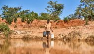 A man fetches water from a pond to water his calves in Matobo, Matabeleland, on May 10, 2024. Photo by Zinyange Auntony / AFP