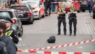 Policemen stand next to a backpack lying on the ground as they secure an area close to the Reeperbahn street and entertainment district following a police intervention on June 16, 2024, hours before the kick off for the UEFA Euro 2024 Group D football match between Poland and the Netherlands.  (Photo by Bodo Marks / dpa / AFP)