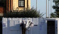 A man hangs a polling station sign on a mobile unit at a Lidl supermarket car park in Loughborough, central England, on July 4, 2024 as Britain holds a general election. (Photo by Darren Staples / AFP)