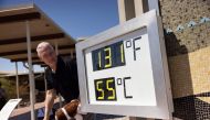 A visitor reacts as he poses next to a thermometer reading “131F, 55C” at the Visitor Center in Death Valley National Park, near Furnace Creek, during a heatwave on July 7, 2024. (Photo by Etienne Laurent / AFP)