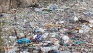 A volunteer searches through a rubbish dump for human remains at Mukuru slum in Nairobi on July 14, 2024. (Photo by Tony Karumba / AFP)