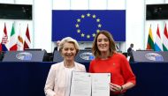 Ursula von der Leyen (R) poses next to European Parliament President Roberta Metsola (R) with document after being elected to a second term as president of the European Commission at the European Parliament in Strasbourg, eastern France, on July 18, 2024. Photo by FREDERICK FLORIN / AFP