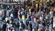 This picture taken on July 25, 2024, shows passengers queuing at the departures hall at Frankfurt's International Airport, western Germany. (Photo by Daniel ROLAND / AFP)