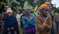 Women weep while residents and volunteers leave for the night after digging in the mud in search for survivors and bodies at the scene of a landslide in Gofa on July 24, 2024. Photo by Michele Spatari / AFP