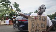 A protestor hold a placard during the End Bad Governance protest in Abuja on August 2, 2024. (Photo by Kola Sulaimon / AFP)