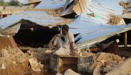 A Sudanese man sits amid the destruction in his village near the northern Sudanese town of Dongola on August 11, 2024 as floodwaters devastated the region disrupting transport, destroying houses and rendering thousands of people homeless. (Photo by AFP)