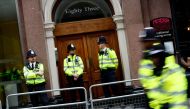 Police officers stand on duty outside the entrace to a building housing the headquarters of the Reform UK political party in London on August 10, 2024. Photo by BENJAMIN CREMEL / AFP.