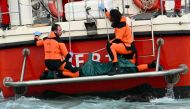 Divers of the Vigili del Fuoco, the Italian Corps. of Firefighters arrive with a body bag at the back of the boat in Porticello near Palermo, on August 21, 2024 two days after the British-flagged luxury yacht Bayesian sank. (Photo by Alberto PIZZOLI / AFP)
